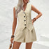 Woman wearing a beige sleeveless dress with buttons against a white background